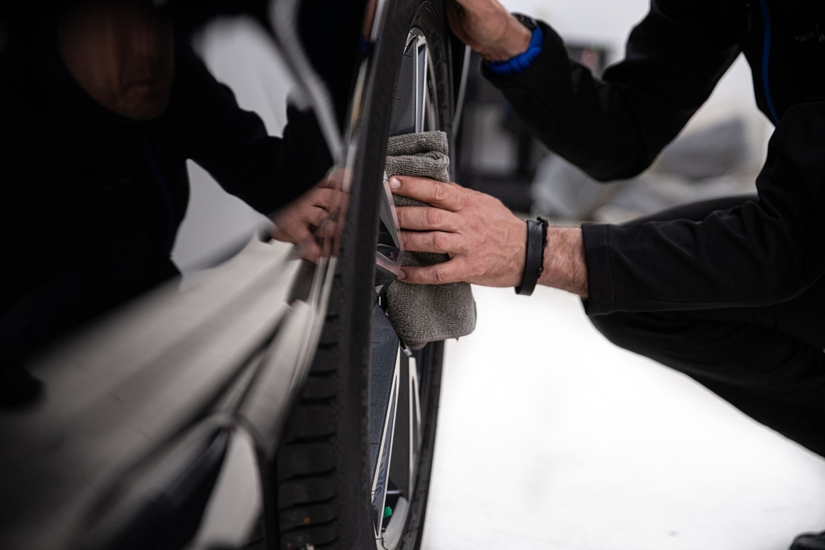 Person cleaning car wheels at a mobile car cleaning franchise