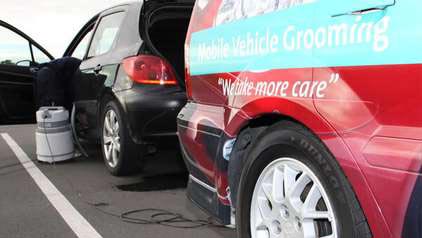 Valet worker vacuuming car